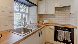 A kitchen with white cabinets, a stainless steel sink, a toaster, and a dishwasher. - 2 Bed in Thornbury (oc-r27561) (Thornbury)