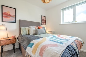 A bedroom with a bed, bedside table, lamp, and two framed pictures on the wall. - 2 Bed in Bude (oc-b27662) (Bude)