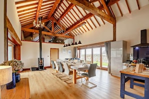 A spacious kitchen with a large dining area, wooden beams, and a view to the outside. - 5 Bed in Menai Bridge (oc-t23240) (Menai Bridge)