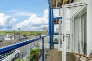 A balcony with a view of the countryside, a wooden fence, and a parked car. - 2 Bed in Penally Near Tenby (oc-g28130) (Penally)