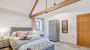 A bedroom with a bed, bedside table, wardrobe, and a large window with curtains. - 1 Bed in Morwenstow (oc-j28166) (Woodford)