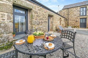A stone building with a round table set for breakfast. - 1 Bed in St. Breward (oc-g28206) (Saint Breward)