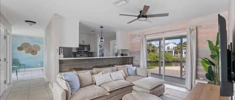 A modern living room with a beige sectional sofa, a wooden coffee table, and a TV on a stand.