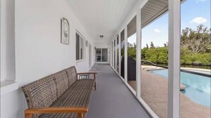 Un'area esterna coperta con piscina, panche e quadri appesi alle pareti.