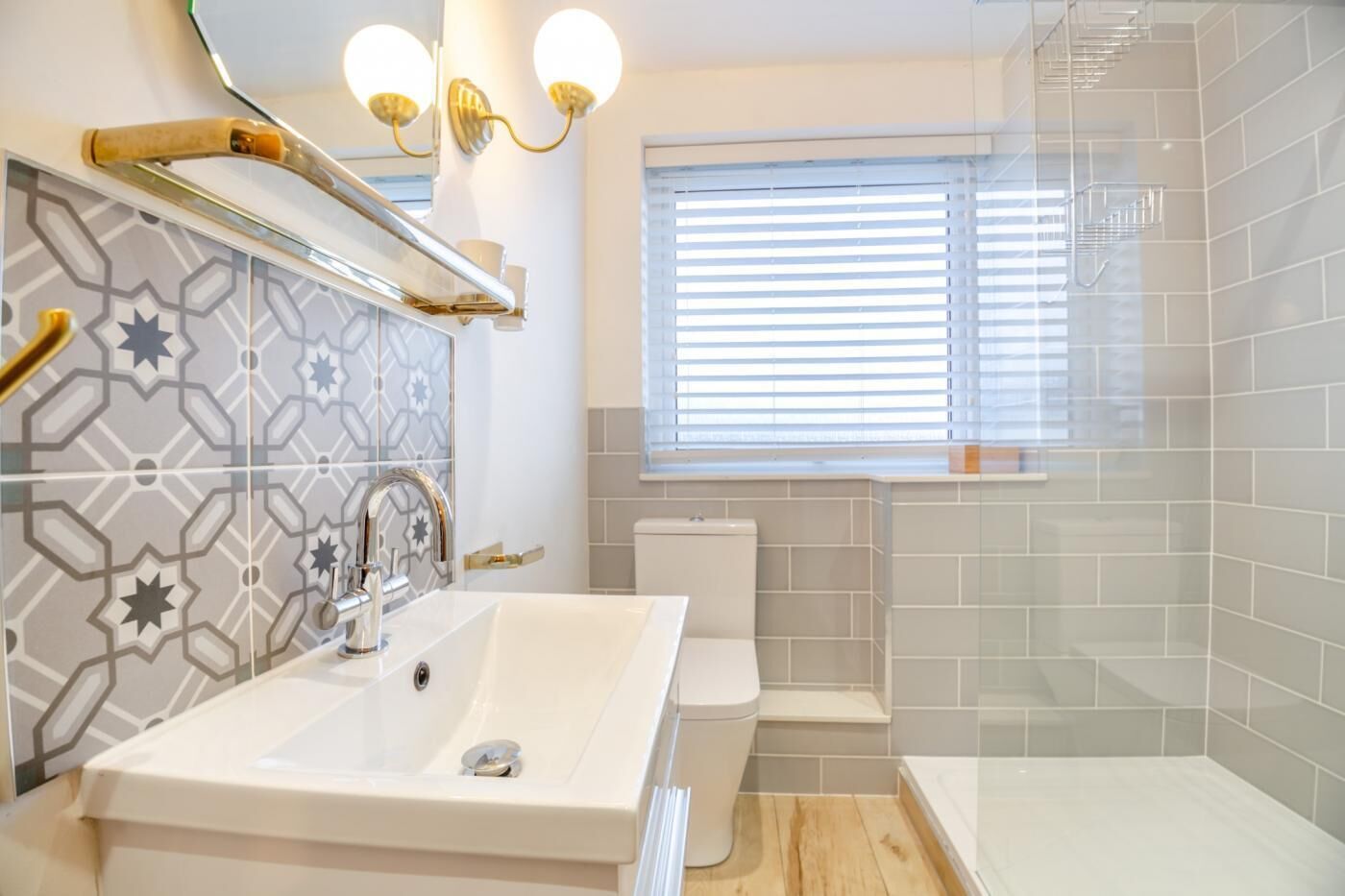 Une salle de bain moderne avec un lavabo blanc, une douche à parois de verre et des toilettes.