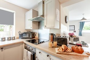 A modern kitchen with a built-in oven, a coffee maker, and a toaster. - 1 Bed in Kilkhampton (oc-s28185) (Kilkhampton)