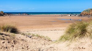 A wide sandy beach with a clear blue sky and calm sea. - 3 Bed in East Chilla (oc-t28939) (Black Torrington)