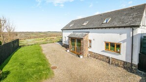A white building with a gravel driveway, a stone foundation, and a grassy yard. - 3 Bed in East Chilla (oc-t28939) (Black Torrington)