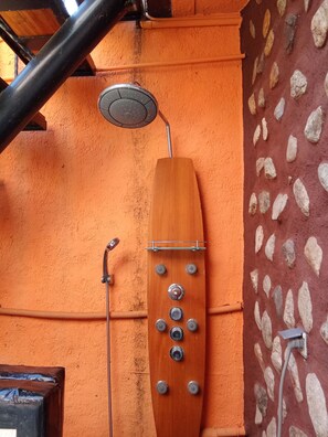 A shower with a wooden handle and multiple knobs, mounted on an orange wall with a stone pattern. - La CATALANE 12 (Argelès-sur-Mer)