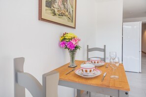 Une table à manger avec un vase de fleurs, des assiettes et des couverts.