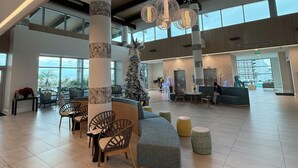 A spacious lobby with high ceilings, large windows, and a central Christmas tree. - Best, New, Luxurious Oceanfront Resort- Myrtle Beach, SC- 2 Bedroom, 2 Bathroom (Myrtle Beach)