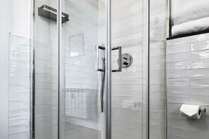 A glass-enclosed shower with a chrome handle and a towel rack. - Alma Suites - Skyline Penthouse (Firenze)