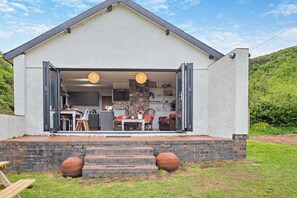 A modern house with a kitchen and dining area visible through open doors. - 2 Bed in Aberdaron (oc-y29261) (Aberdaron)