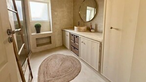 A bathroom with a window, a round mirror, a sink, and a towel rack. - Charming house with pool, 10 min from La Rochelle (Dompierre-sur-Mer)