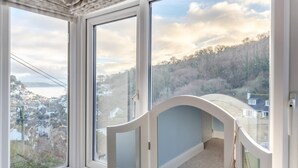 A room with large windows overlooking a town and hills. - 3 Bed in Looe (oc-s29266) (Looe)