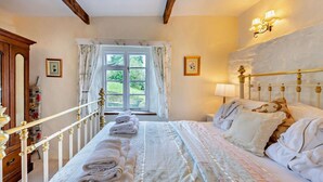 Un dormitorio con cama, ventana, cómoda y lámpara.