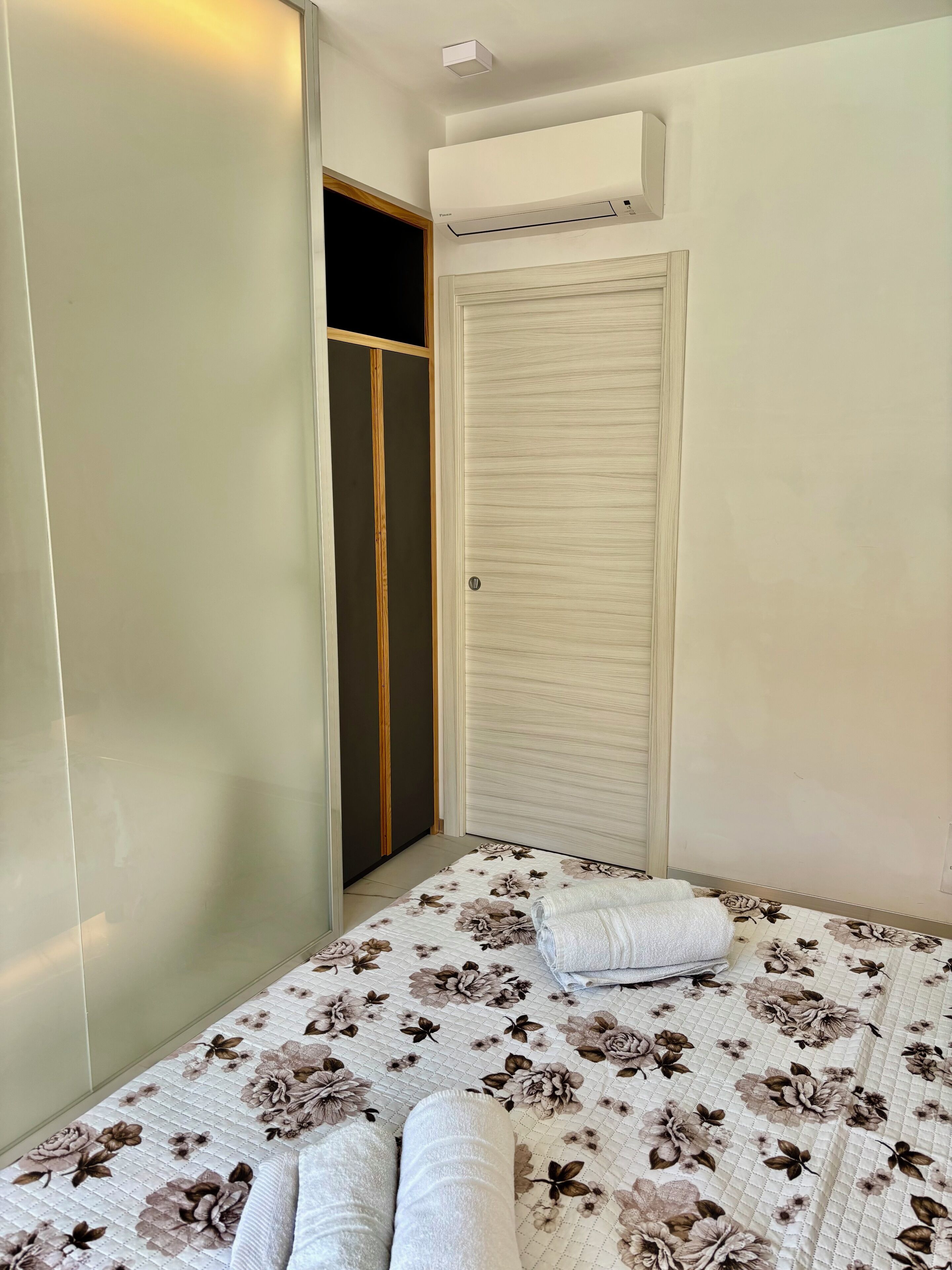 Ein Schlafzimmer mit einem Bett, einem Kleiderschrank und einer Klimaanlage.