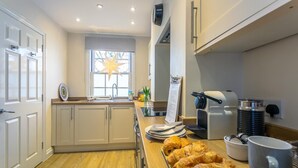 A modern kitchen with a wooden countertop, a coffee machine, and a star-shaped window decoration. - 2 Bed in Rye (oc-52470) (Rye)