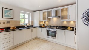 A modern kitchen with white cabinets, a gas stove, and a built-in oven. - 4 Bed in Abersoch (oc-b29438) (Abersoch)