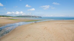 A wide sandy beach with a clear sky and distant hills. - 4 Bed in Abersoch (oc-b29438) (Abersoch)