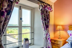 A bedroom with a window, curtains, a bedside lamp, and a vase on the windowsill. - 2 Bed in Middleton (oc-m29515) (Middleton)