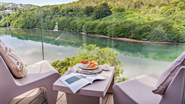 A table with a meal and a book, overlooking a river and forested hills. - 3 Bed in Looe (oc-j29456) (Looe)