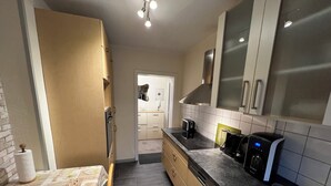 A compact kitchen with a stove, toaster, and coffee maker. - A central, cozy family retreat for 4 people—perfect for short getaways (Bremerhaven)