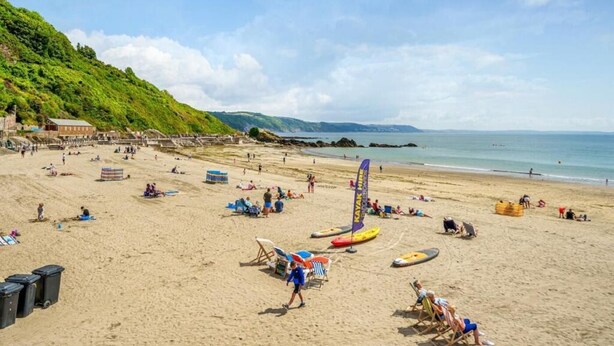 A beach with kayaks, beach chairs, and umbrellas. - 2 Bed in Looe (oc-a29612) (Looe)