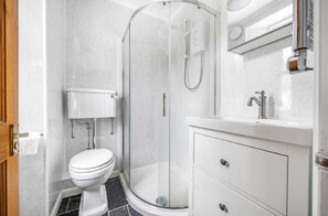 A modern bathroom with a glass-enclosed shower, a toilet, and a vanity with drawers. - 2 Bed in Looe (oc-a29612) (Looe)