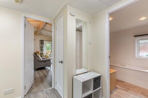 A hallway with a sofa, a small table, and a window.