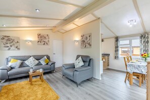 A modern living room with two grey sofas, a wooden coffee table, and a yellow rug. - 2 Bed in Swarland (oc-b29805) (Swarland)