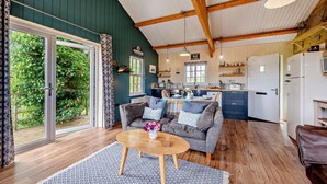 A cozy interior with a sofa, coffee table, and a view of a garden through a sliding door. - 1 Bed in Dre-Fach Felindre (oc-a29876) (Felindre)