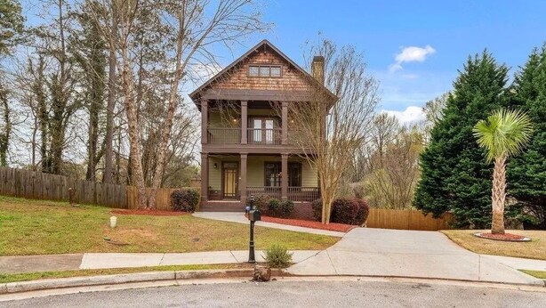 A two-story house with a front porch, surrounded by trees and a well-maintained lawn. - Near Downtown and Midtown, Quiet Cul-de-sac Decatur Home with Deck & Balcony, (Decatur)