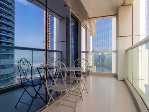 Ein Balkon mit Blick auf eine Stadtlandschaft, mit modernen Gebäuden und blauem Himmel.