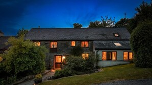 A two-story stone house with a sloped roof, multiple windows, and a well-maintained garden. - 4 Bed in Hebron (oc-y30097) (Whitland)