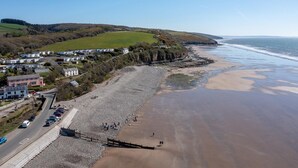 A coastal area with a beach, houses, and a road. - 2 Bed in Llangain (oc-g30185) (Llangain)