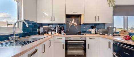 Mikrobølgeovn, ovn, oppvaskmaskin og høy barnestol