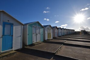 Eine Reihe von Strandhäusern unter blauem Himmel und Sonnenschein.