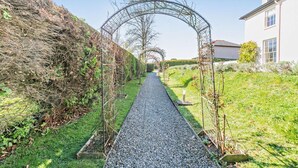 A pathway lined with a metal archway, flanked by a hedge and a building. - 2 Bed in North Tamerton (oc-t30362) (North Tamerton)
