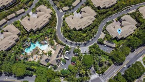 An aerial view of a resort with multiple bungalow-style buildings, a central swimming pool, and well-maintained landscaping. - Luxurious Ho'olei 12-2, Lush View, Close to Pool, Sleeps 8 in Beds, Central AC! (Kihei)