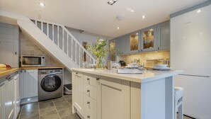 A modern kitchen with a built-in washing machine, a microwave, and a refrigerator. - 2 Bed in Fowey (oc-r30265) (Fowey)