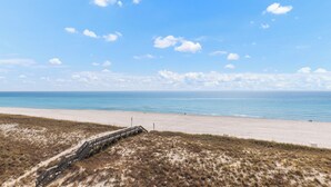 Ein Strand mit einem Holzsteg, der zum Ufer führt.