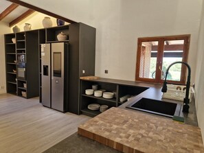A modern kitchen with built-in appliances, a wooden countertop, and a window with a view. - Villa Son Felip (Palma)