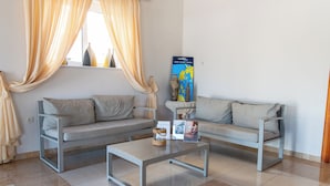 A modern living room with two sofas, a coffee table, and a poster on the wall. - Elektra Hotel (Paleros)
