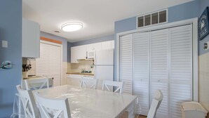 A compact kitchen with white cabinets, a microwave, and a refrigerator. - Club Ocean Villa II 119 (Ocean City)