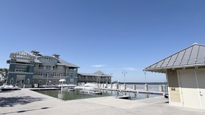En ejendom ved vandet med en stor bygning, swimmingpool og et lille pavillon.