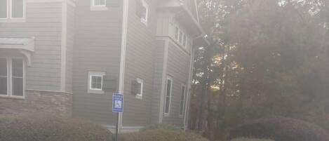 A parking area with a handicapped parking space marked by a blue sign and painted symbol.