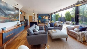 Un vaste espace de vie comprenant un grand salon, une cuisine et un coin repas.