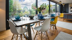 Un espace repas doté d’une grande fenêtre, d’une table en bois et de chaises.