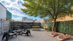 An outdoor seating area with a table, chairs, and a tree.